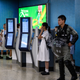 Policemen in riot gear stand guard as a group of high school students gather inside the Kowloon Tong subway station.